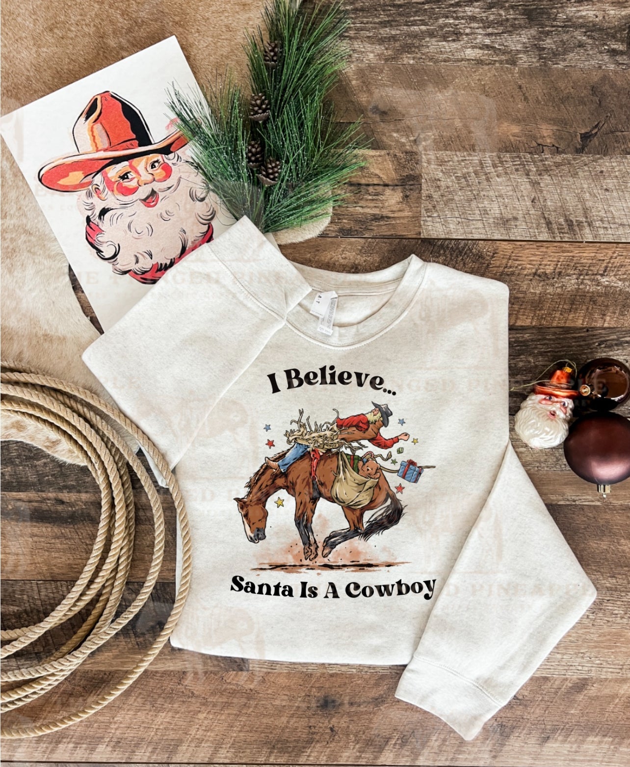 I Believe Santa Is A Cowboy Tee or Sweatshirt (Heathered Cream/Cream)